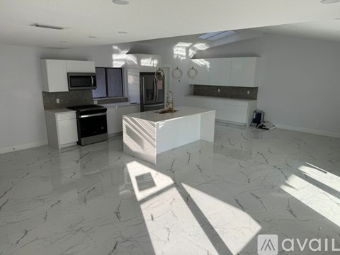 A modern kitchen with a black stove top oven and a white island.
