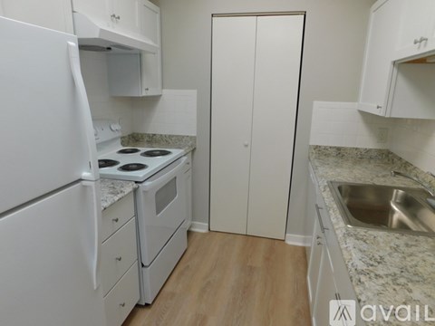 A kitchen with white appliances and cabinets.
