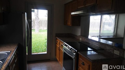 A kitchen with a refrigerator, sink, and oven.