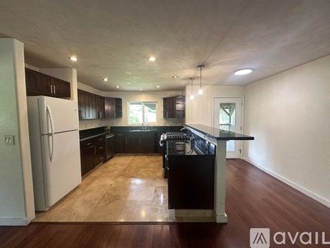 A kitchen with a refrigerator, cabinets, and a countertop.
