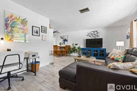 A living room with a black couch and a white chair.
