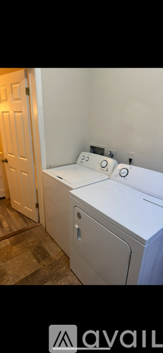 A white washing machine in a room with a door.