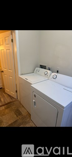 A white washing machine in a room with a door.