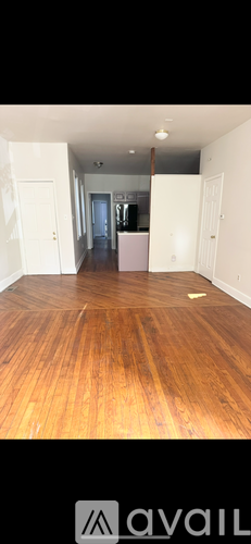 A room with wooden flooring and white walls.