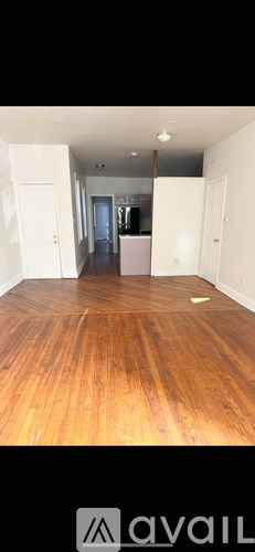 A room with wooden flooring and white walls.