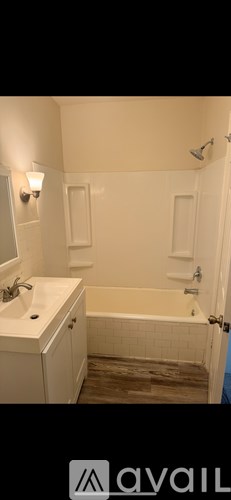 A bathroom with a white sink and a bathtub.