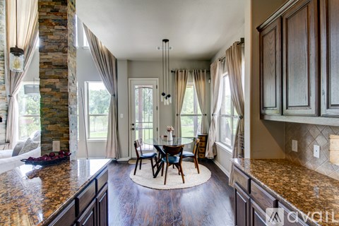 A kitchen with a table and chairs in the middle of the room.