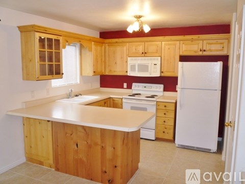 A kitchen with wooden cabinets and white appliances.