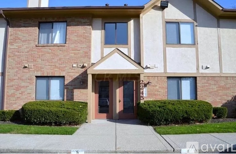 A brick building with a brown door and windows.