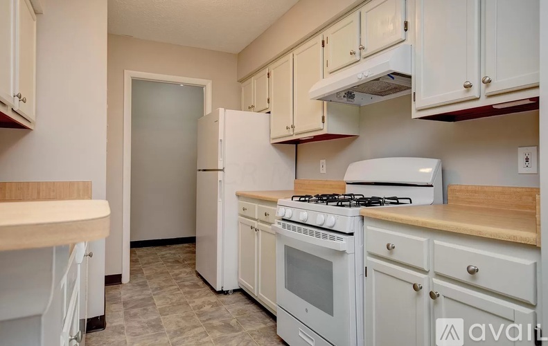 A kitchen with white appliances and cabinets.