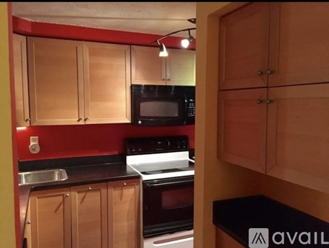 A kitchen with wooden cabinets and black countertops.