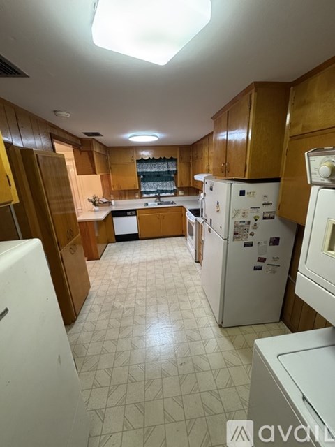 A kitchen with wooden cabinets and white appliances.