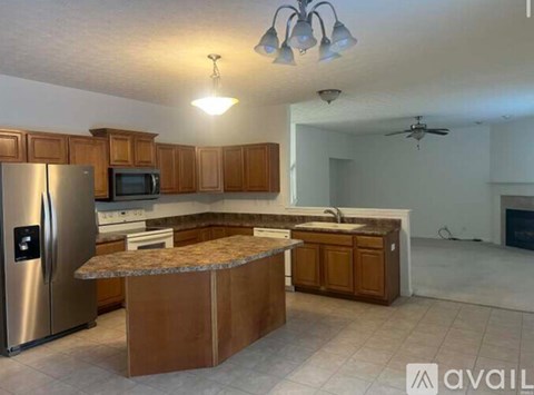 A kitchen with a refrigerator, microwave, oven, and sink.