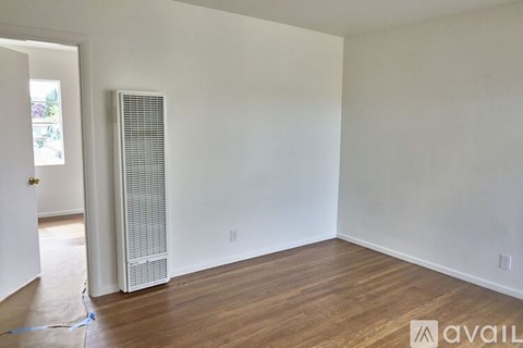 A room with a white wall and a white air conditioner unit.