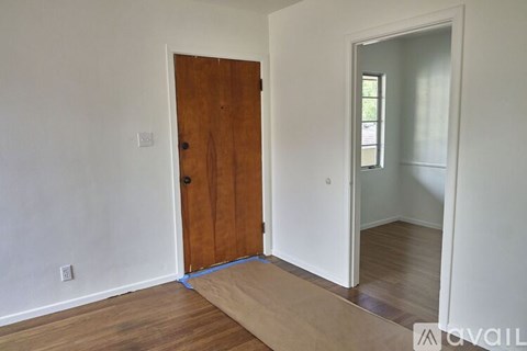 A room with a brown door and a white wall.