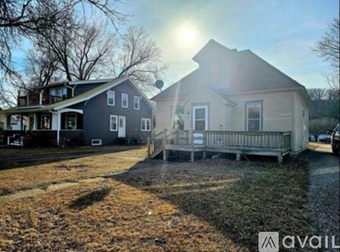 A house with a porch and a car parked in front.