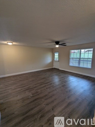 A room with wooden flooring and a ceiling fan.