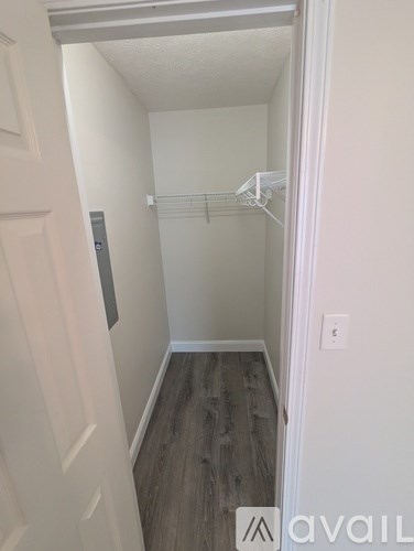 A small, empty room with a white door and a white wall.
