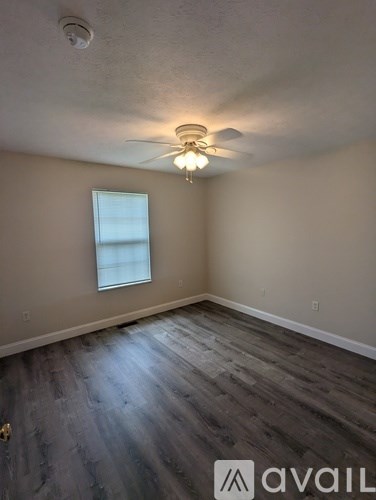 A room with a ceiling fan and a window.