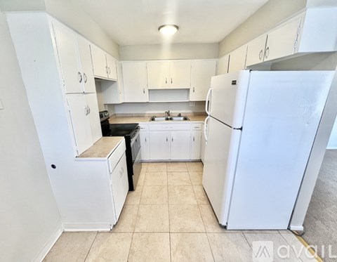 A kitchen with white appliances and cabinets.