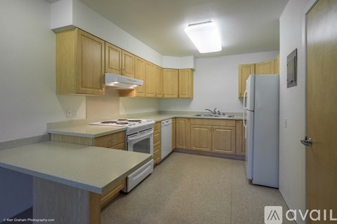 A kitchen with wooden cabinets and a white refrigerator.
