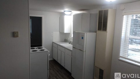 A kitchen with white appliances and cabinets.