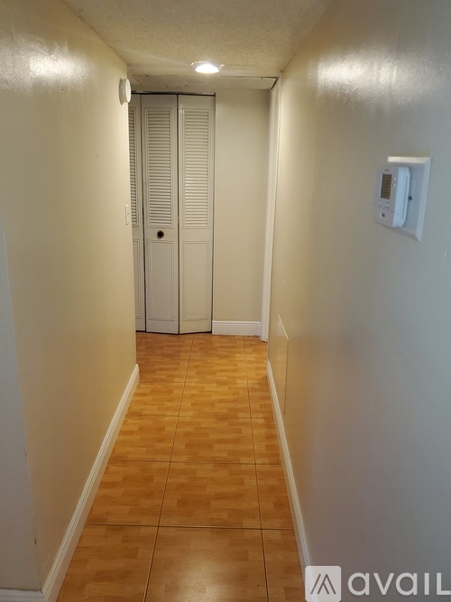 A long hallway with a white door at the end.
