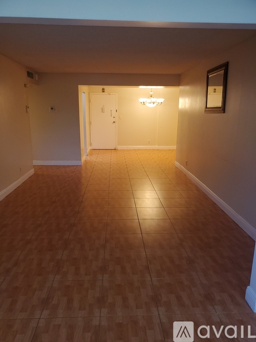 A room with wooden flooring and a chandelier.