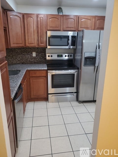 A kitchen with wooden cabinets and stainless steel appliances.