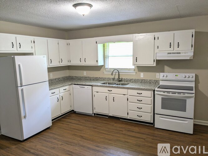 A kitchen with white appliances and cabinets.