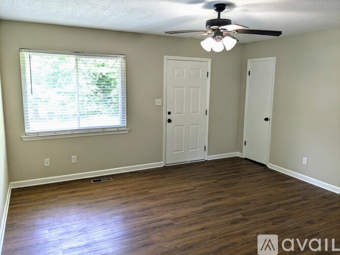 A room with a ceiling fan and two doors.