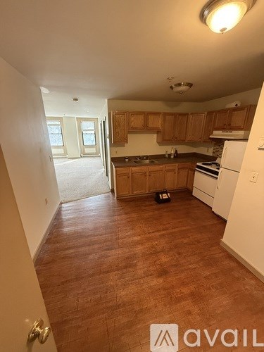 A kitchen with wooden cabinets and a white fridge.