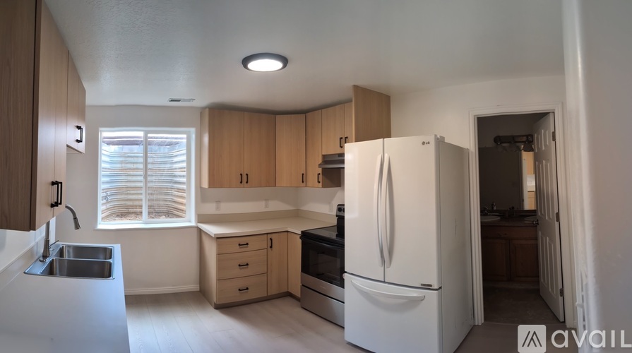 A kitchen with white appliances and wooden cabinets.