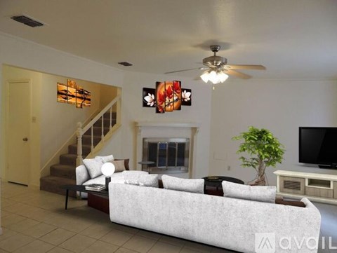 A living room with a white couch and a ceiling fan.