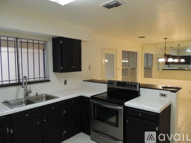 A kitchen with black cabinets and a white countertop.