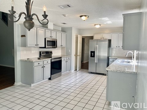 A kitchen with white cabinets and appliances.