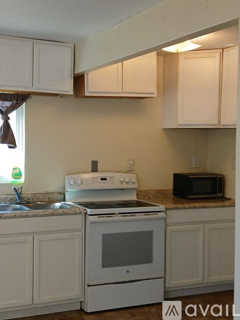 A kitchen with a white oven and microwave.
