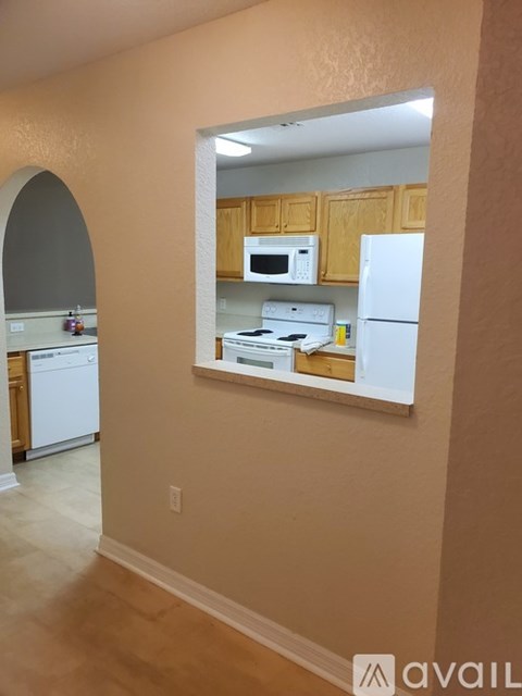 A kitchen with a white refrigerator and a mirror on the wall.