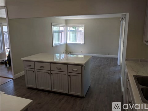 A kitchen with a white countertop and cabinets.