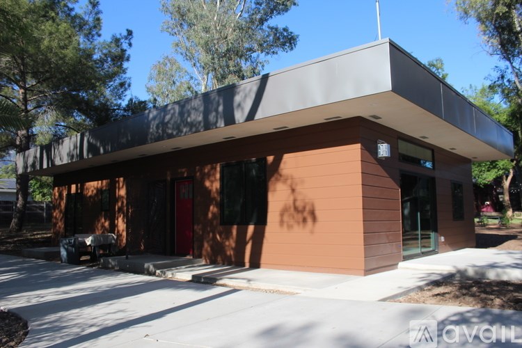 A small building with a red door and a grey roof.