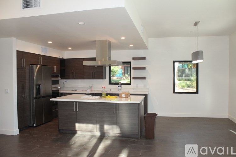 A modern kitchen with a large island and stainless steel appliances.