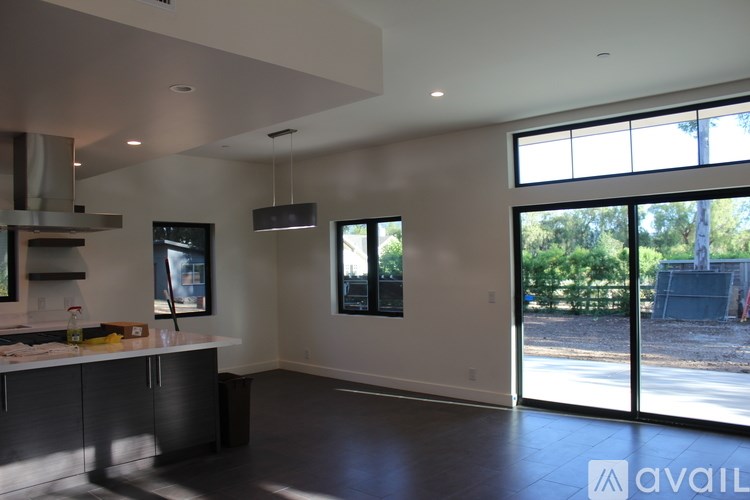 A modern kitchen with a large island and a view of the outdoors.