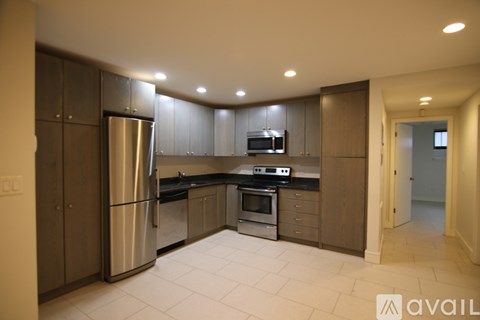 A modern kitchen with stainless steel appliances and wooden cabinets.