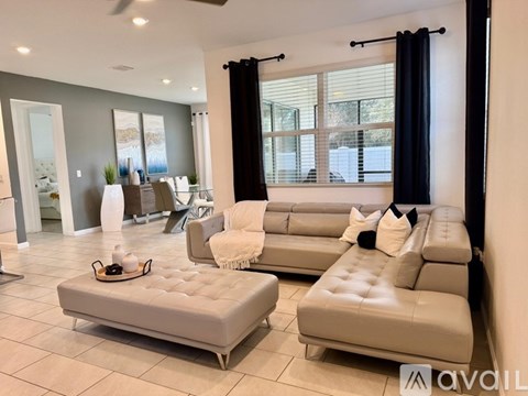 A living room with a grey couch and ottoman.