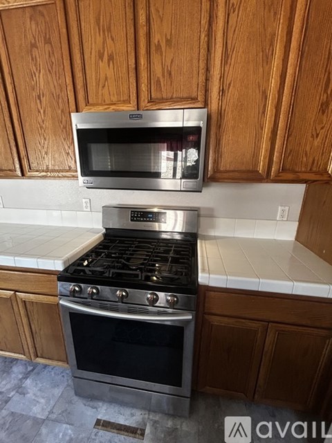 A kitchen with a stove and microwave above it.