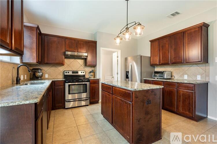 A kitchen with wooden cabinets and a granite countertop.