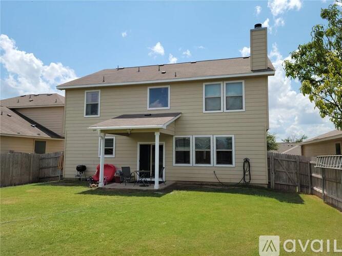 A house with a beige exterior and a red chair on the porch.