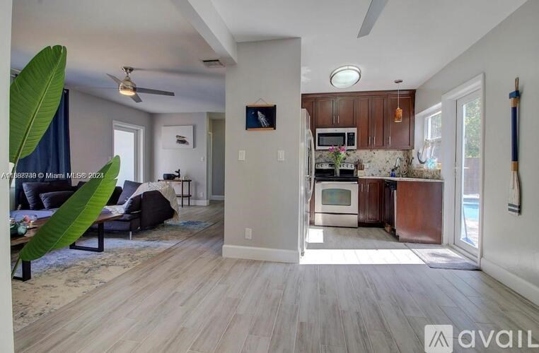 A living room with a couch, a television, and a ceiling fan.