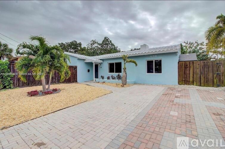 A house with a blue exterior and a driveway in front.