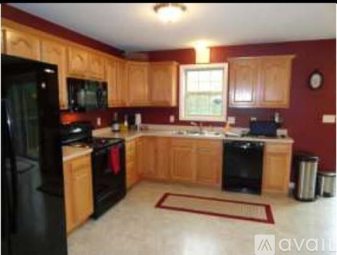 A kitchen with wooden cabinets and black appliances.